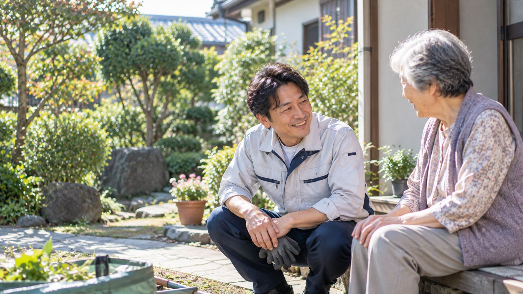 庭先で高齢の女性と並んで話す様子