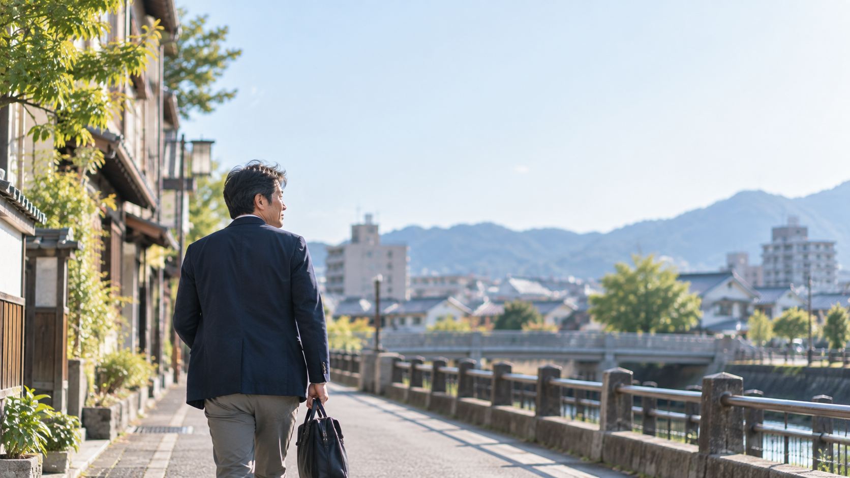 街の川沿いの道を歩いていく後ろ姿